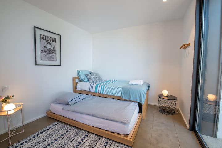 Спалня с 2 легла и тераса с достъп до R+1. Двете легла могат да бъдат монтирани на едно и също ниво.