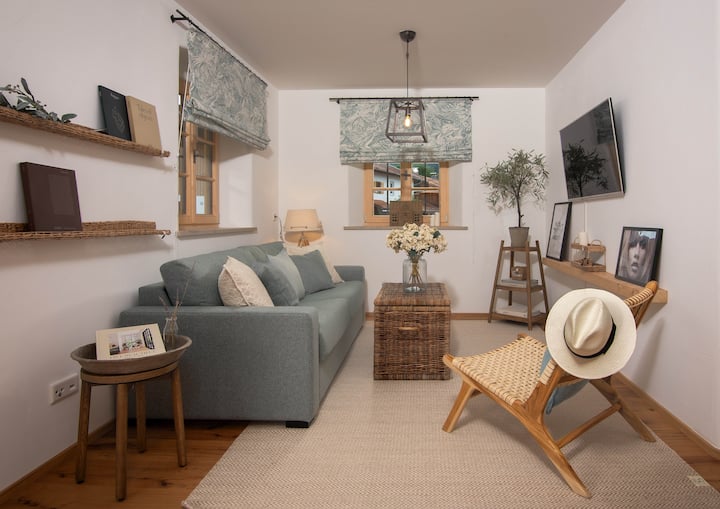 Სასადილო სივრცის მიმდებარედ არის ჩვენი ლამაზი მისაღები ოთახი განსაკუთრებული ხიბლით მშვიდი საათების განმავლობაში.
Სმარტ-ტელევიზორი Netflix ‑ ით, RTL+ ‑ ით, ასევე, Magenta TV ‑ ით, ასევე, კომფორტული დიზაინის დივანი „ზის“ ‑ დან, რომელიც სწრაფად გადაიქცევა დედოფლის ზომის საწოლად