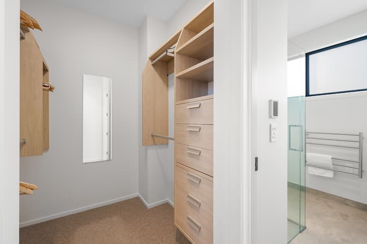 Une armoire généreusement proportionnée rejoint le lit et la salle de bain attenante.