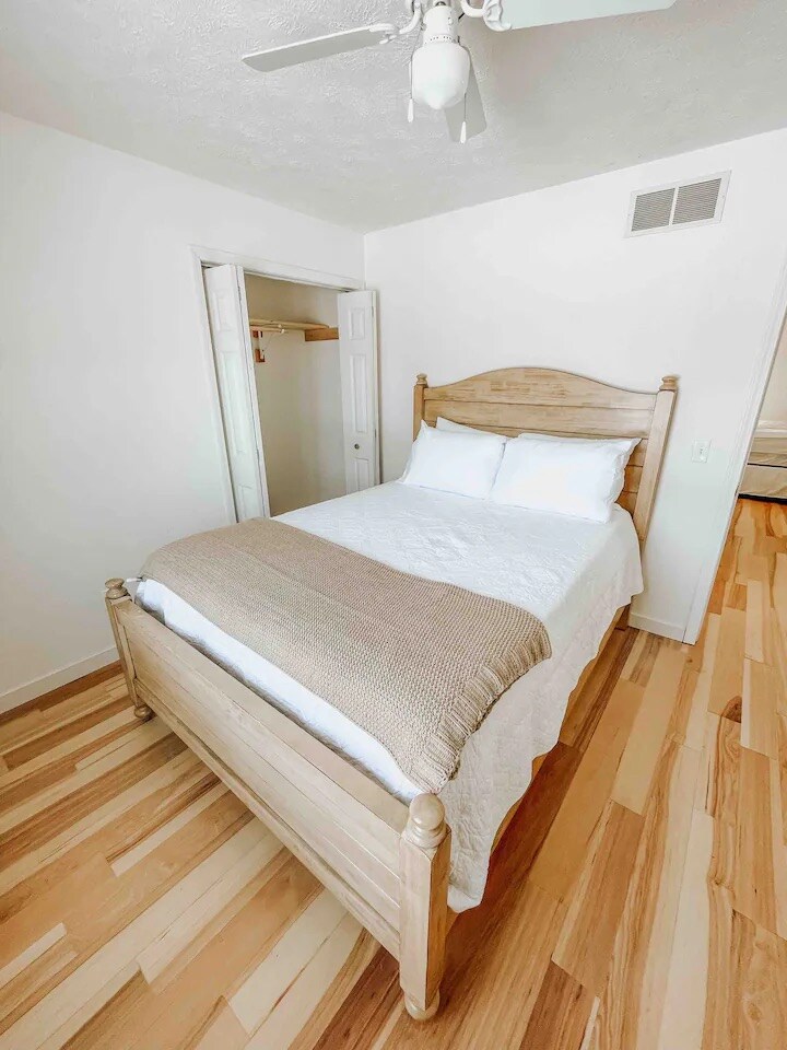 غرفة النوم الرئيسية مجهزة بسرير كوين أسفل القاعة مباشرة من بقية البيت