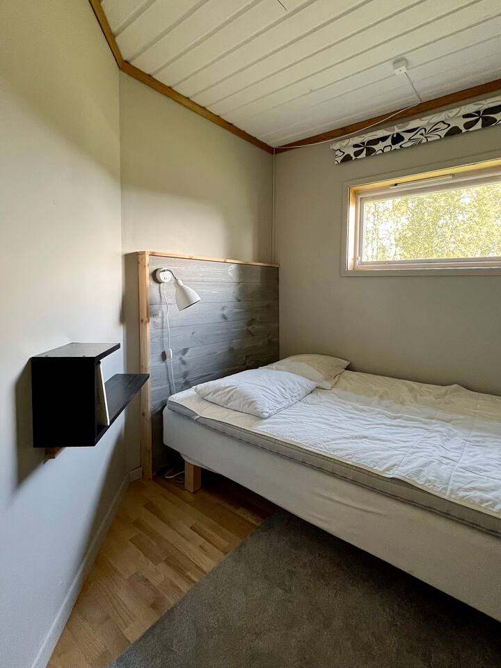 Manja spavaća soba s malim bračnim krevetom. 