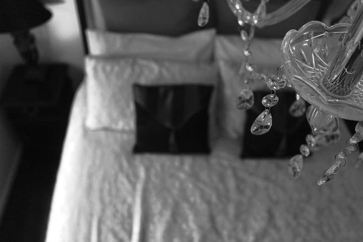 Dormitorio 2: Royal Kingdom Suite - Cuenta con vistas al frente de la propiedad con una gran cama de hierro fundido y lámpara de araña. (Cama tamaño queen) Con los mejores colchones de lujo del Hilton Hotel y ropa de cama de lujo de diseño Sheridan/ Hemp con lámparas de araña de cristal.