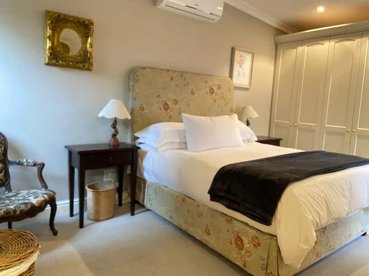 Chumba kikubwa cha kulala chenye kiyoyozi na nafasi kubwa ya kabati.