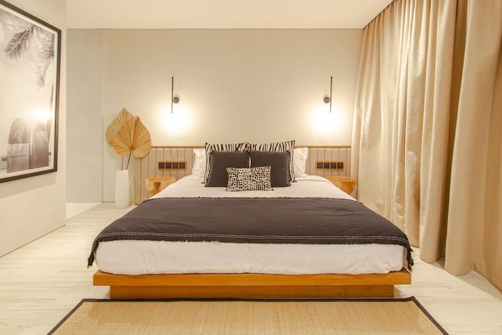 Unwind in this tranquil bedroom haven, complete with subtle lighting and natural textures. A plush bed, layered with soft linens, guarantees restful nights. Elegant decor and spaciousness create a calming retreat.