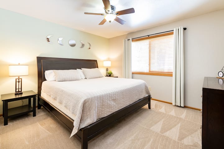 Pumzika kwa starehe ukiwa na kitanda cha ukubwa wa kifalme, mapazia ya kuzima na feni ya kuburudisha kwa ajili ya starehe. Furahia stendi mbili za usiku zinazoambatana na taa zinazoweza kupunguka, huku ukiangalia mwonekano tulivu wa ua wa nyuma. Tumia kabati na kabati lenye nafasi kubwa wakati wa ukaaji wako