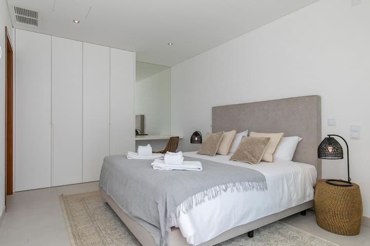 Dormitorio doble con acceso a la piscina:	un dormitorio doble con cama tamaño king y acceso directo al área de la piscina cuenta con una cómoda cama y un diseño espacioso. Las puertas corredizas de vidrio se abren hacia un patio con tumbonas.		