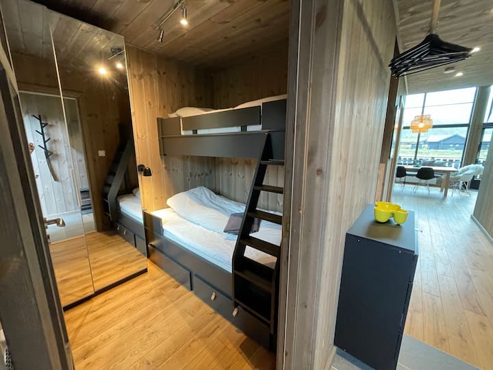 Chumba cha 2 cha kulala upande wa kushoto huanza na kitanda cha ghorofa chenye upana wa sentimita 120 chini na sentimita 90 juu. Sehemu ya kabati.