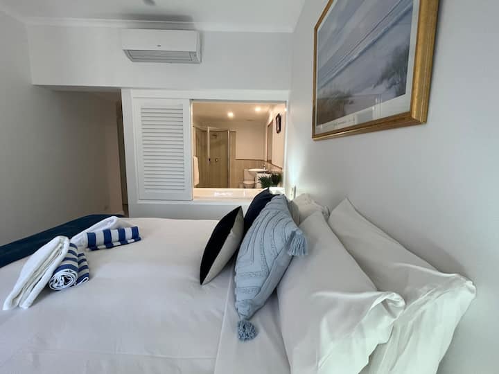 Основна спалня с двойно легло и телевизор, монтиран на стената