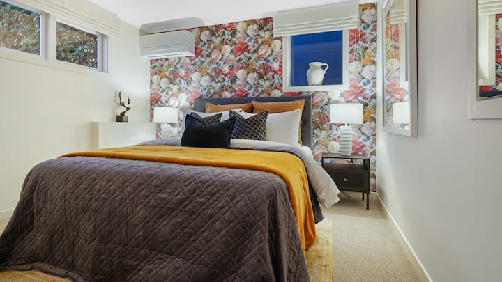 El dormitorio 4 está ubicado en la planta baja y tiene un papel pintado de rosa distintivo y una cama tamaño queen.