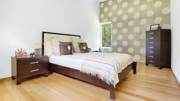 Une chambre spacieuse offre une chambre abondante avec des plafonds hauts, des fenêtres sur trois murs et une ambiance nouvellement conçue.  Regardez les cerfs se promener depuis les fenêtres avant et arrière !