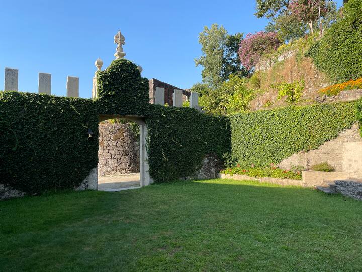 Jardín con arco de piedra cubierto de hiedra. Compartido por todos los huéspedes.