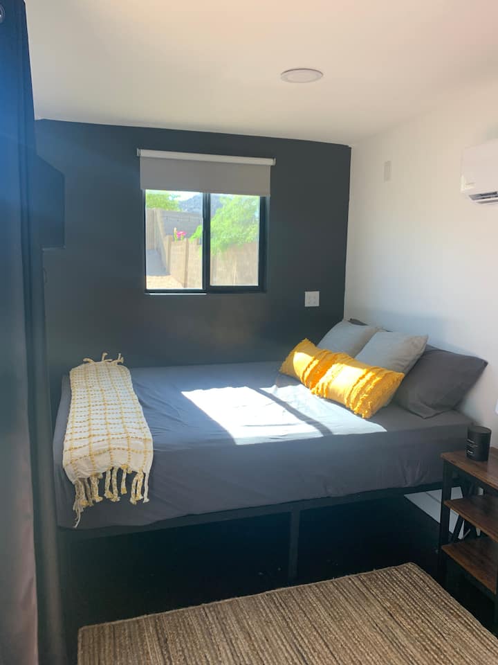 Kitanda cha ukubwa wa malkia kilicho na kivuli cha giza cha chumba