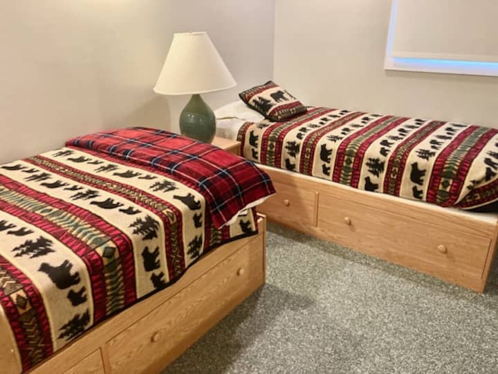 Dormitorio 2 en planta alta, dos camas individuales con almacenamiento de cajones.