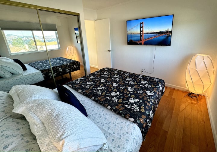 Comfortable bedroom with TV. This cozy bedroom features a comfortable bed, wall-mounted TV, and a large mirrored closet.