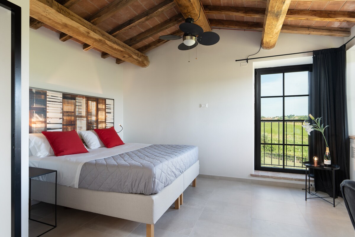 Disfruta de la comodidad de una suite de lujo con una cama doble y vistas impresionantes de las colinas toscanas