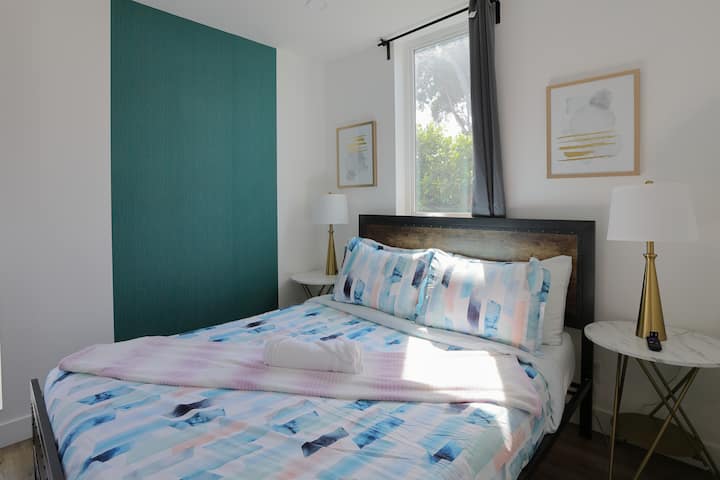 Détendez-vous confortablement avec un lit queen confortable et une télévision murale ;  la retraite parfaite après une longue journée.