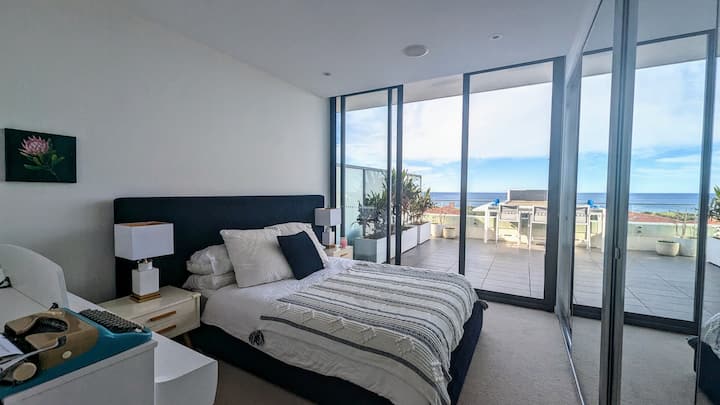 Glavna spavaća soba s bračnim krevetom i kupaonicom, pamučnim plahtama, ukrasnim jastucima, dva noćna ormarića i svjetla, prozorima od poda do stropa i ugradbenim ogledalom, sjenilo za zamračivanje, centralna klima-uređaj, zvučnici Sonos na stropu, Yamaha klavir. Plus pogled na ocean!