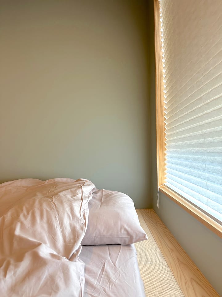 El pequeño espacio de tatami en el dormitorio tiene una ventana para luz suave.Si el sol es demasiado fuerte, se puede ajustar bajando la pantalla de doble balanceo.