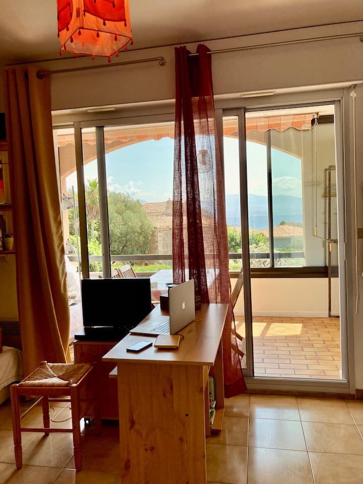 изглед от апартамента с отляво на първия разтегателен диван, а вдясно - отворената кухня. След първия плъзгащ се залив влизате в лоджията (с втори разтегателен диван).