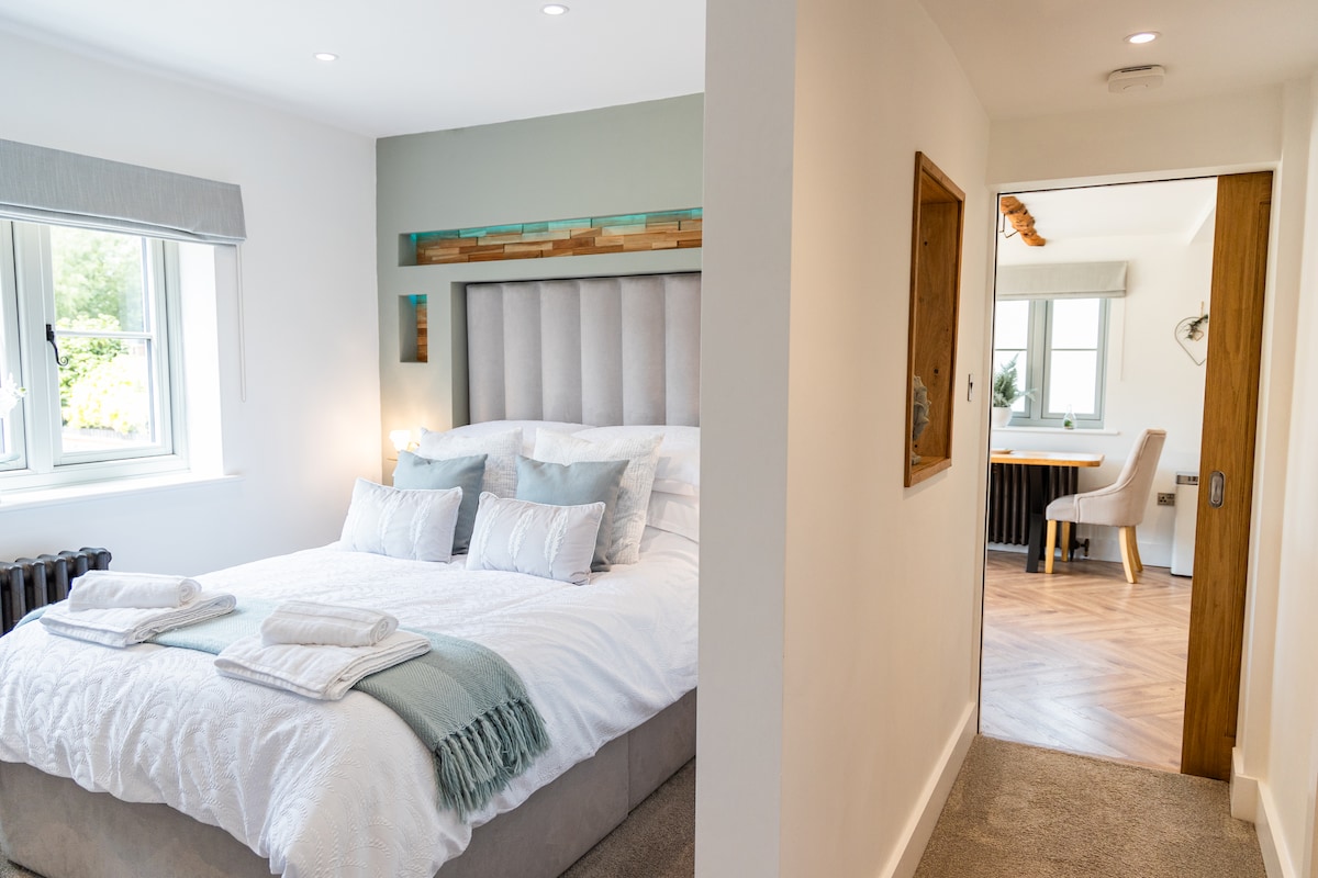 双人床，配备豪华床罩和床上用品。