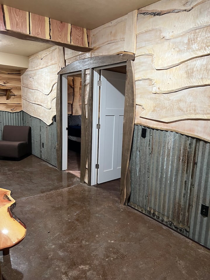 المدخل إلى غرف النوم في الطابق السفلي مكسو بالقصدير المموج المعاد تصميمه من أحد المباني الملحقة المتقاعدين. 