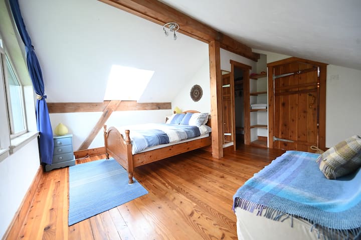 ห้องนอนคู่ชั้นบนพร้อมเตียงโซฟา