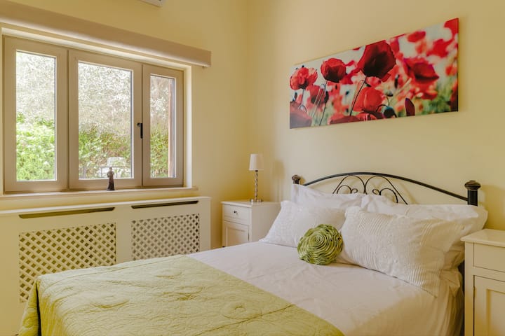 Dormitorio doble ubicado en la planta baja con armarios empotrados del piso al techo y televisión amurallada, así como persianas de control remoto.