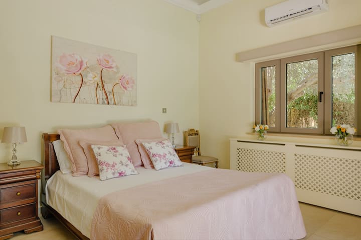 Dormitorio totalmente equipado en la planta baja con puertas dobles que conducen a las terrazas envolventes y a la piscina. 