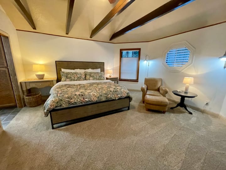 Dormitorio principal con cama tamaño king y baño en suite, vestidor grande. Silla de cuero y TV por cable