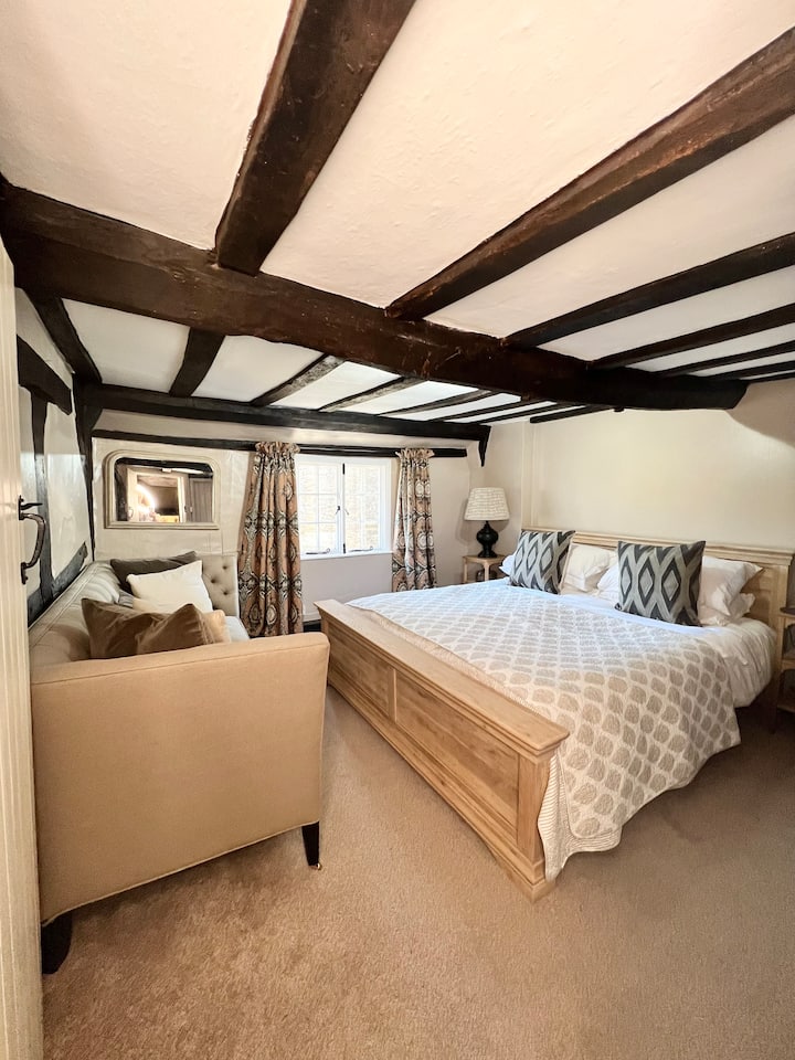 سرير سوبر كينج وأريكة كبيرة للاسترخاء فيها 