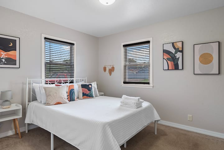 Დედოფლის საძინებელი ელეგანტური ავეჯით, რომელიც მოიცავს ღამის სანათს, გვერდით მაგიდას და დეკორაციებს, რომლებიც უპრობლემოდ ერწყმის ოთახის საერთო ესთეტიკას.