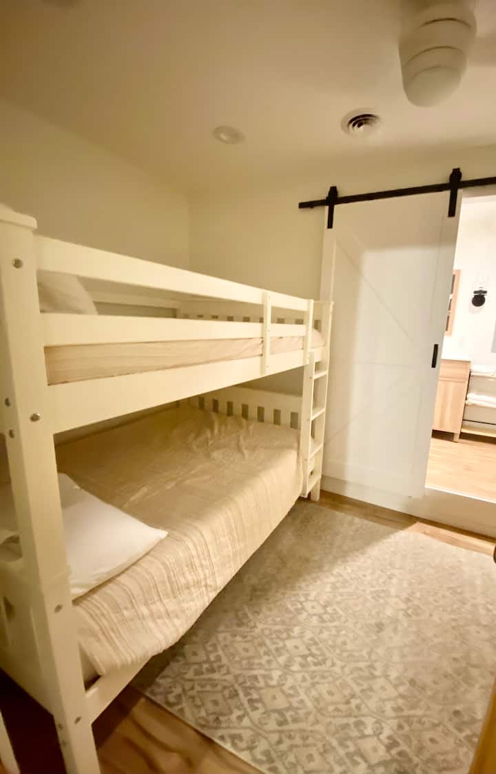 Nivel inferior con literas de dos camas, acceso a través de la habitación con cama king y comunicado con el baño completo