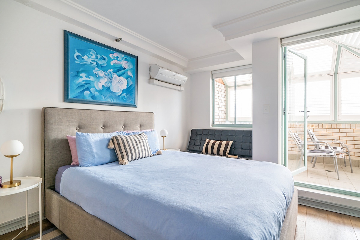 La chambre principale à l'étage dispose d'un coin lecture avec un canapé et un accès à un balcon ensoleillé. 
