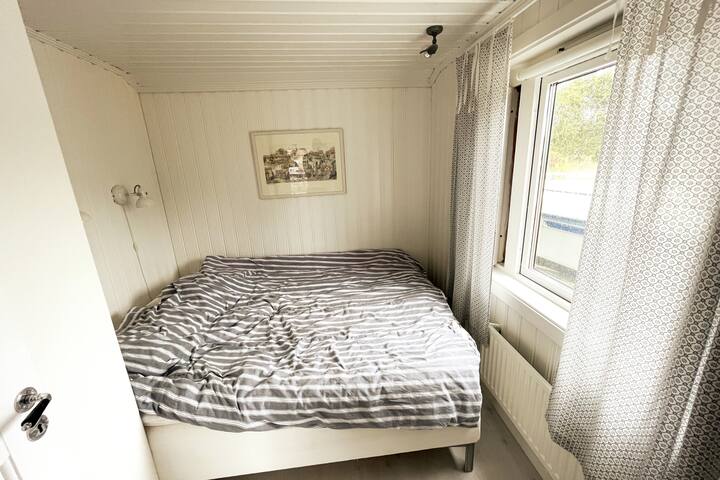 Chumba cha kulala katika nyumba ya shambani yenye kitanda kidogo cha watu wawili (upana wa mita 1.6). Makabati mawili yako kwenye chumba cha kulala.