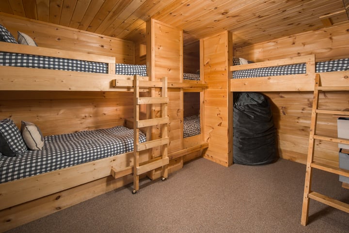 Habitación con una litera con 5 camas de una cama y una tumbona de frijoles gigantes.