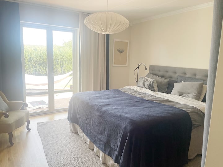 Spavaća soba 1 s bračnim krevetom i izlazom prema stražnjoj strani kuće. 