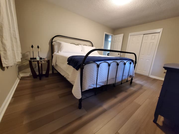 A spacious bedroom featuring a king bed and it's own Roku TV.