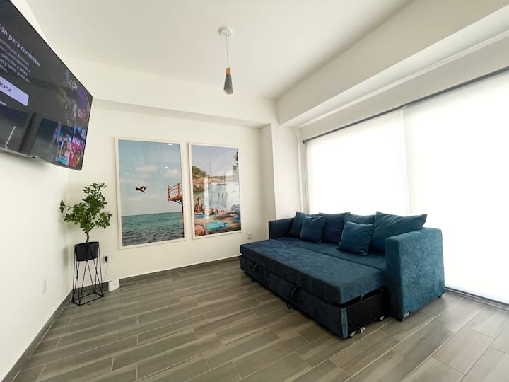 Salon avec canapé double et smart TV