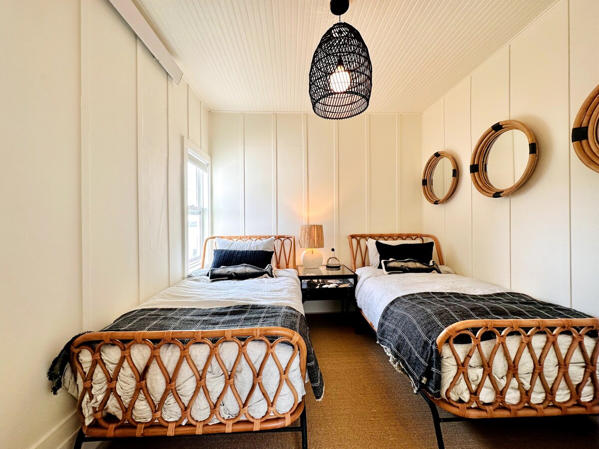 Segundo dormitorio con 2 camas individuales. Ropa de cama de lujo en paracaídas. Vistas del agua desde la pequeña ventana.