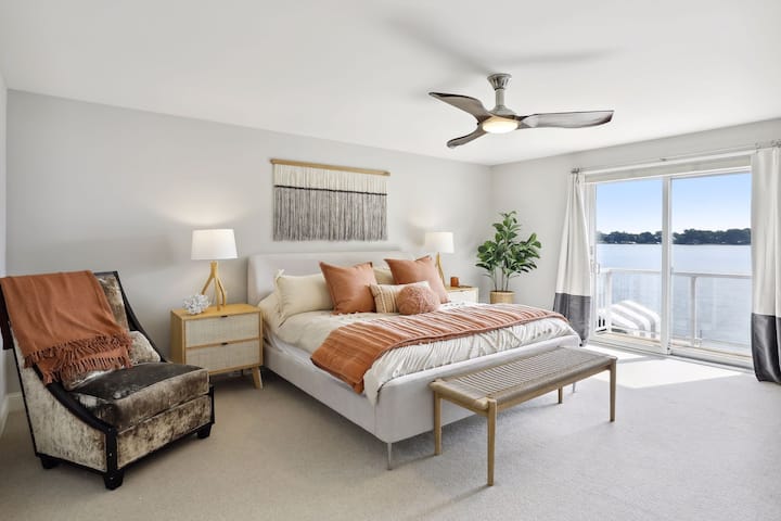 Grande chambre principale au 2e étage, avec vue sur les espaces de vie en contrebas, belle vue sur le lac avec balcon et salle de bain principale attenante. 