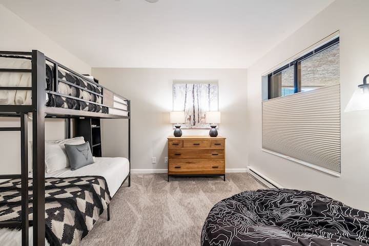 חדר ילדים עם מיטות קומתיים וכיסא פוף שמתקפל למזרן מלא