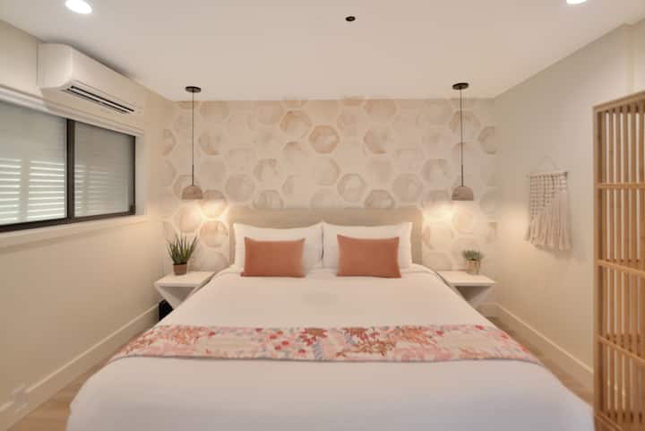 Спалня, подобна на спа, с двойно легло, висящо осветление, спално бельо, пухкави възглавници, ефективно мини сплит, шкаф за съхранение на предметите ви и голямо огледало на стената. 