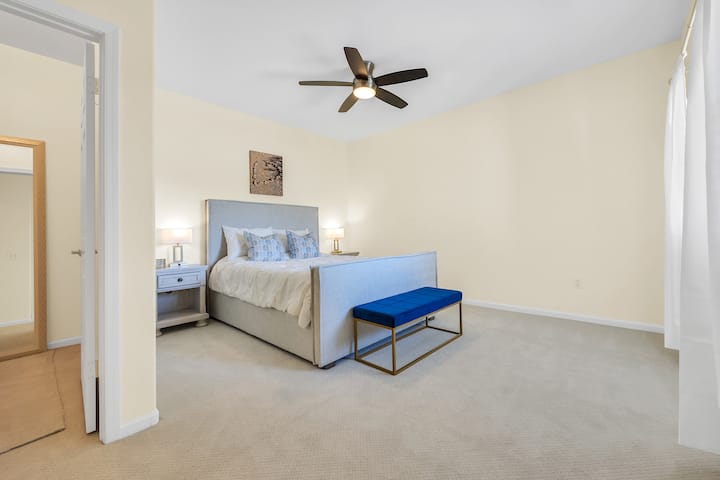 El dormitorio principal tiene una cómoda cama queen y acogedoras sábanas.  Toca las luces activadas junto a la cama. ¡Haz que la lectura en la cama sea muy fácil!