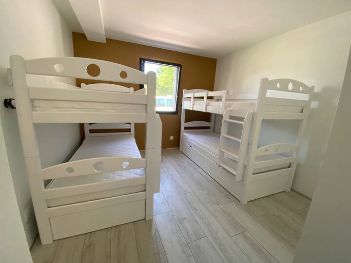 Chambre offrant 5 couchages simples 
Lits superposés robustes en bois massifs 
- 1 lit : 2 * 90 x 200
- 1 lit : 2 * 90 x 200 + 1 * 90 x 190