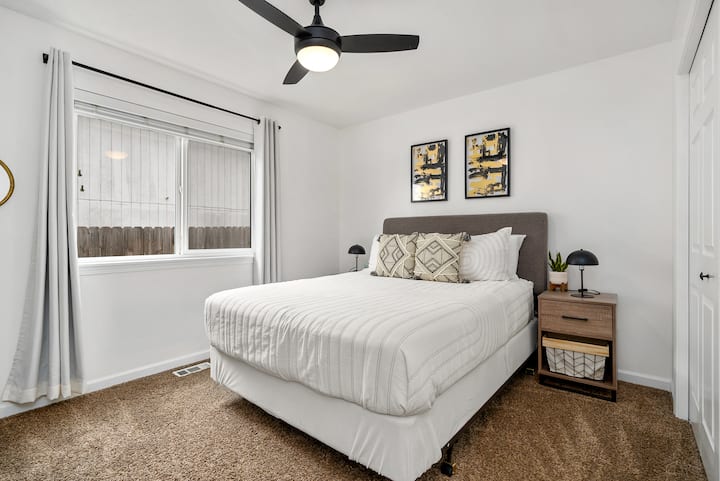 ห้องเตียงควีนไซส์พร้อมสมาร์ททีวีขนาด 55 ”พัดลมเพดานและม่านสีเข้มในห้อง 