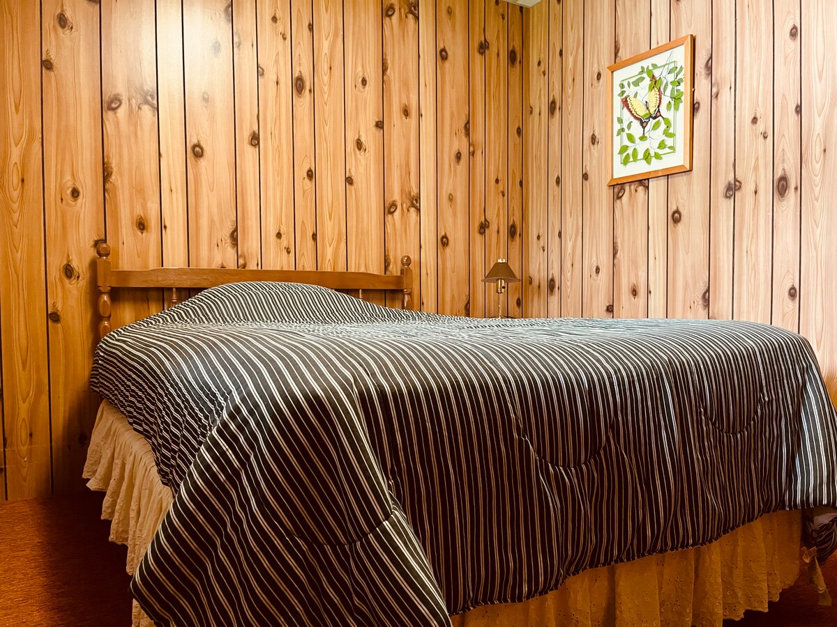 חדר שינה בקומה התחתונה עם מיטה זוגית.