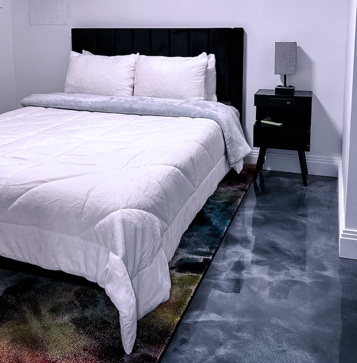 Სარდაფის საძინებელი საწოლით, სმარტ-ტელევიზორითა და სამუშაო სადგურით.