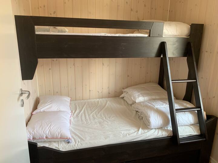 Spálne s rodinnou posteľou, 80/120 cm. Veľký úložný box pod posteľou a háčiky na jednoduché uskladnenie. Okno je orientované na vstupnú stranu. Je tam zatemňovací záves. Nezabudnite si priniesť vlastnú posteľnú bielizeň.