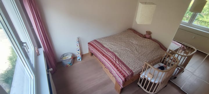 מיטה זוגית בחדר שינה עם מיטת תינוק נוספת