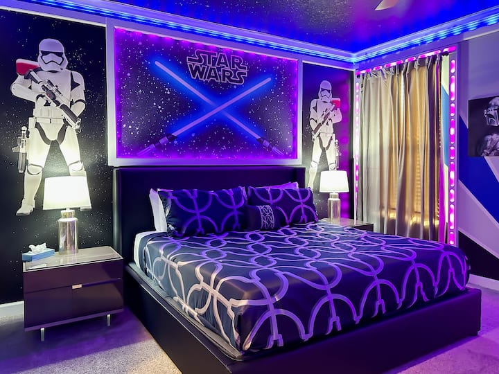 Ostvarite svoje snove u ovom epskom smještaju iz Ratova zvijezda! Crni zidovi s efektom galaksije okružuju elegantni krevet na podiju, a sa svake strane nalaze se murali s likovima Stormtroopera. Neonski LED obrub i osvijetljeni ukršteni svjetlosni mačevi stvaraju atmosferu, dok panorama kontrolne sobe i umjetnička djela Mandalorijanca     